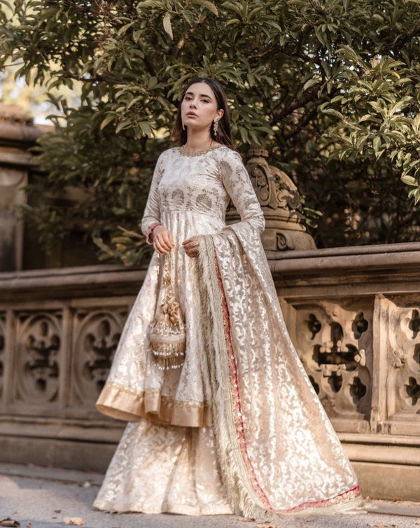 White and gold embroidered sharara with gold dupatta. 